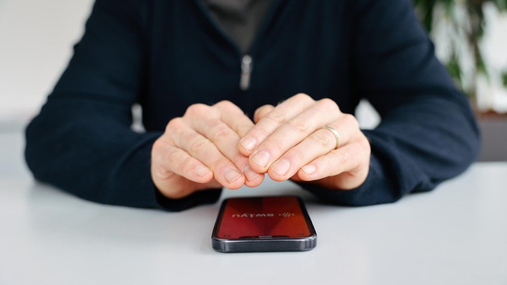 Zwei Hände über einem Mobiltelefon